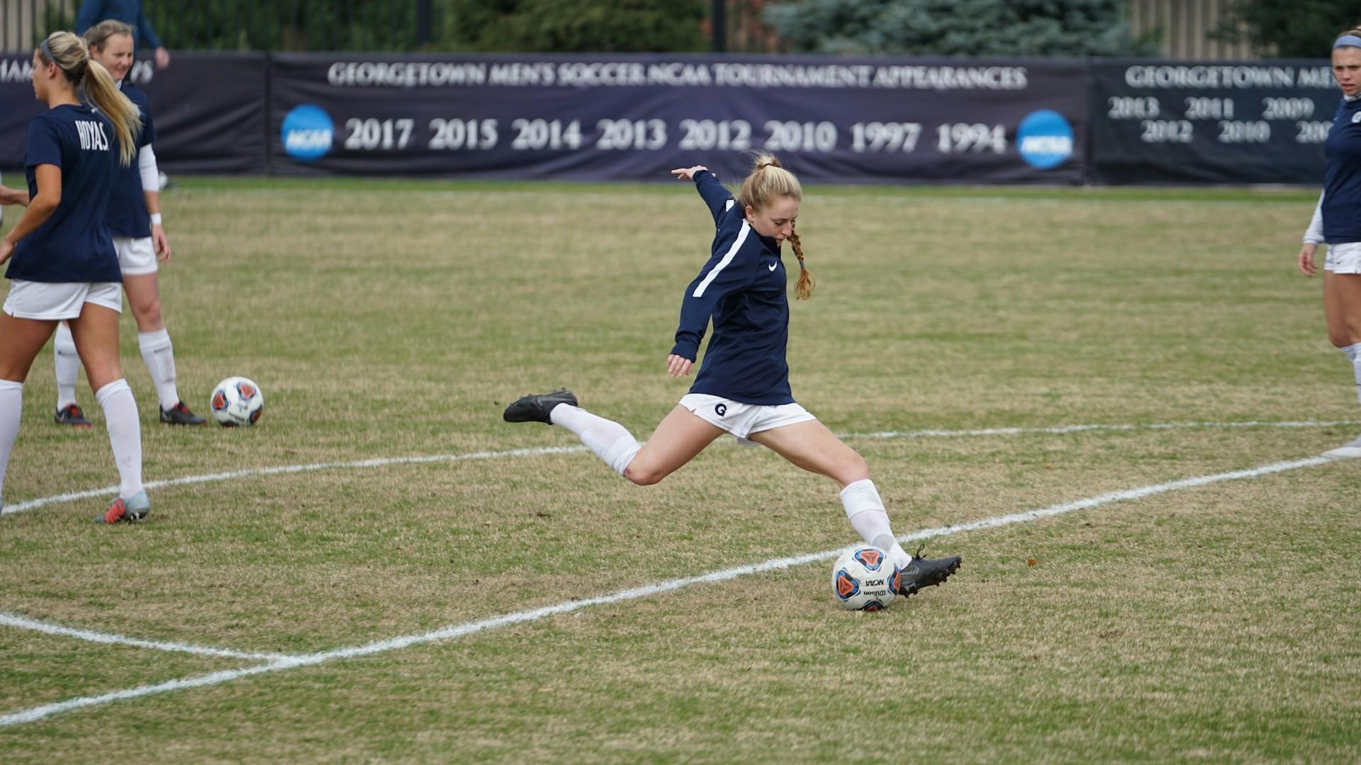 Female soccer player in action kicking the ball during a game.